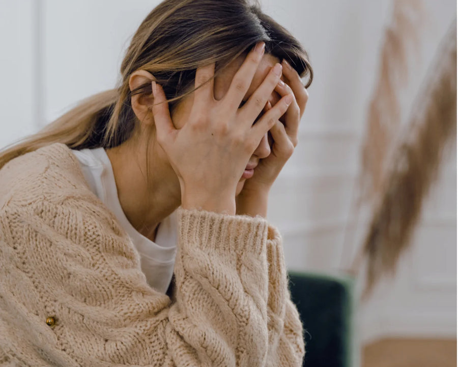 Femme blonde stressée, de mauvaise humeur, se tenant la tête dans les mains