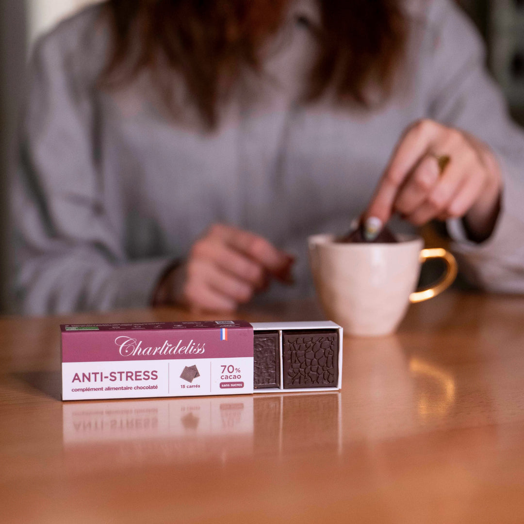 Femme rousse trempant dans son café son complément alimentaire antistress et stabilisateur d'humeur sous forme de carrés de chocolat noir 70% de cacao sans sucres. Le meilleur chocolat pour régime ou pour les diabétiques.