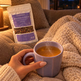 Moment cocooning sous un plaid avec une tasse de Rituel Zeste de Sérénité